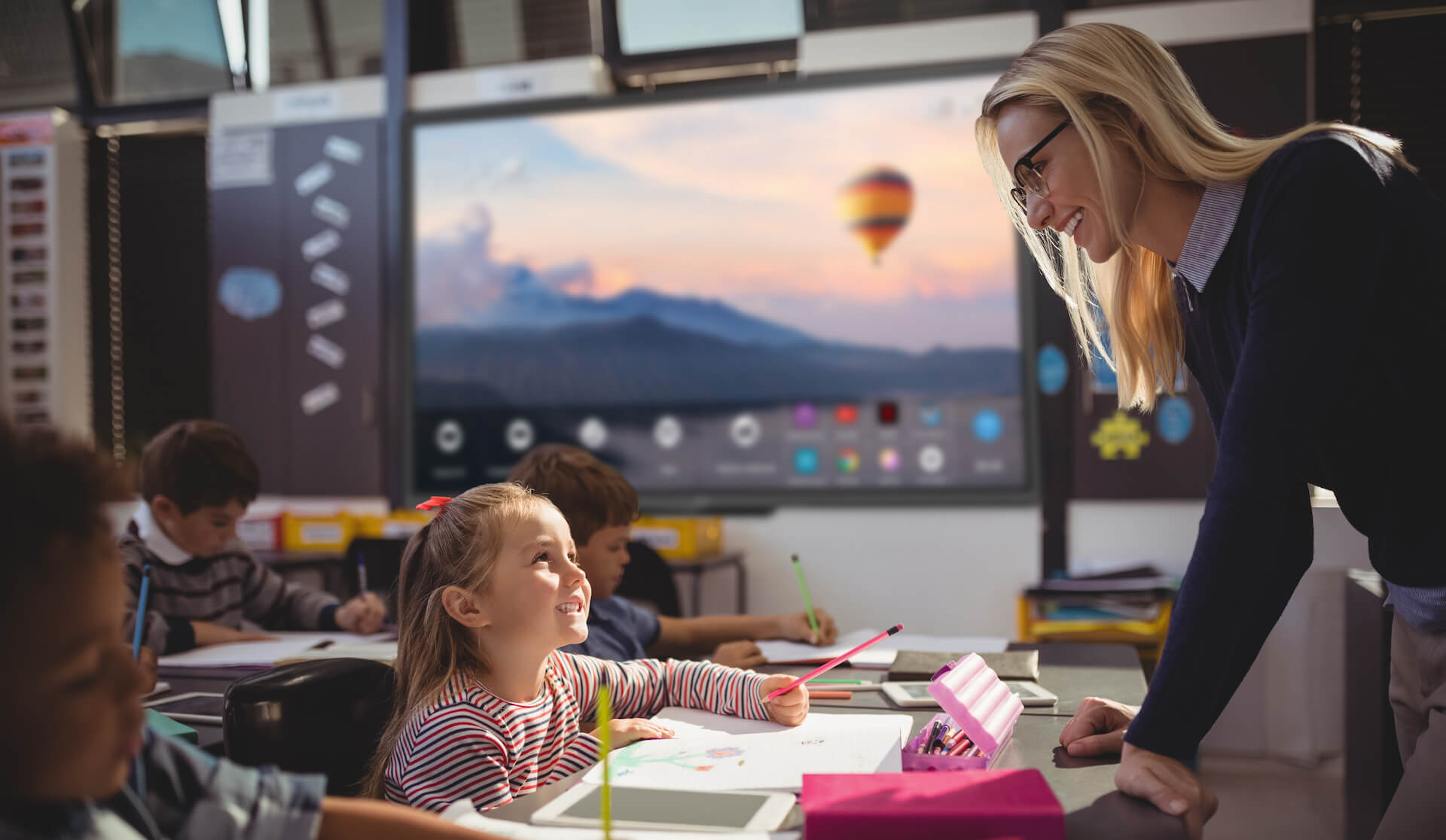 Teacher interacting with schoolgirl in classroom