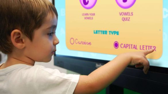 young student touching interactive display